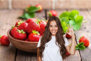 donna sorridente che fa ok con le mani e fragole